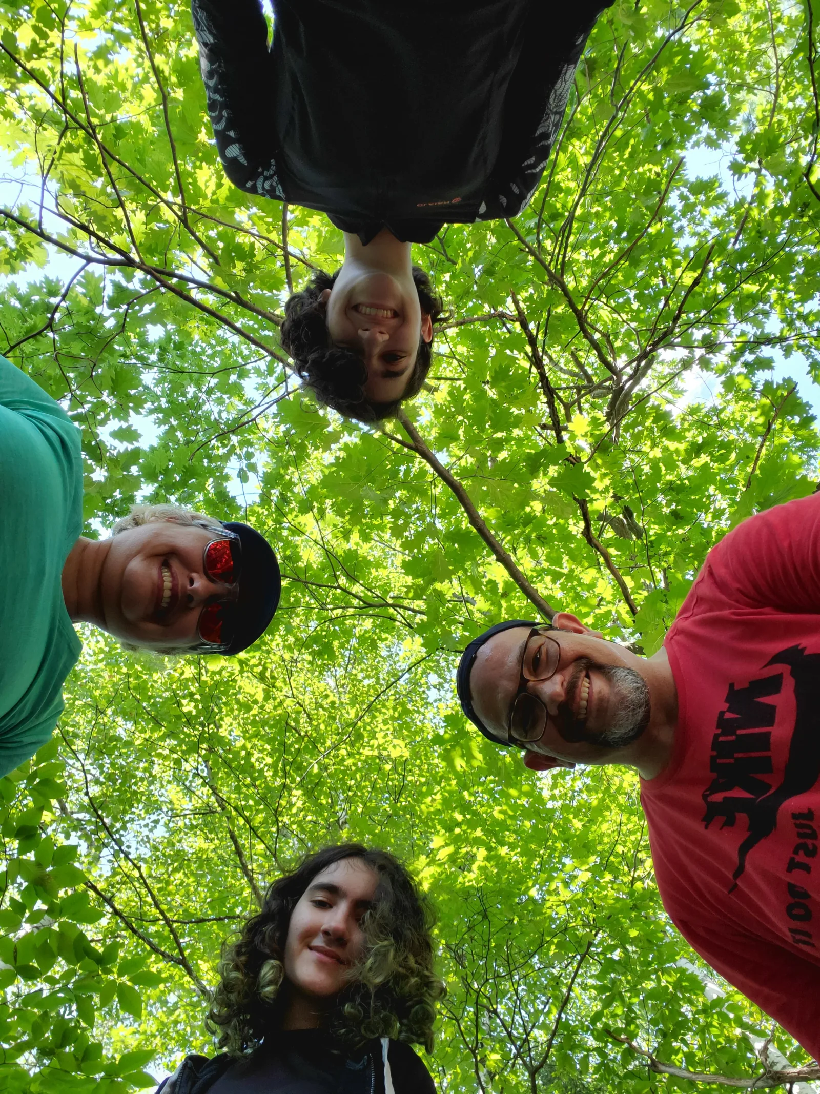 Retrato divertido da família sob a copa verde da floresta de Sainte-Ursule